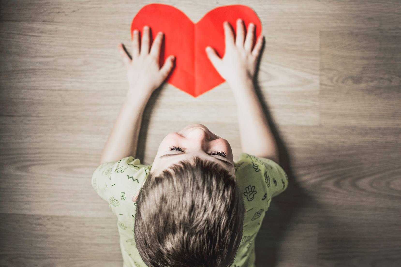 Bambino con un cuore di carta