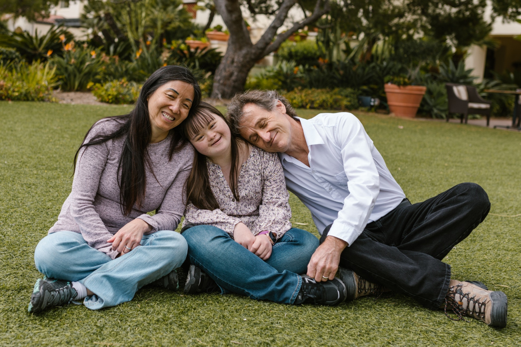 famiglia di tre persone: mamma, papà e figlia con sindrome di Down