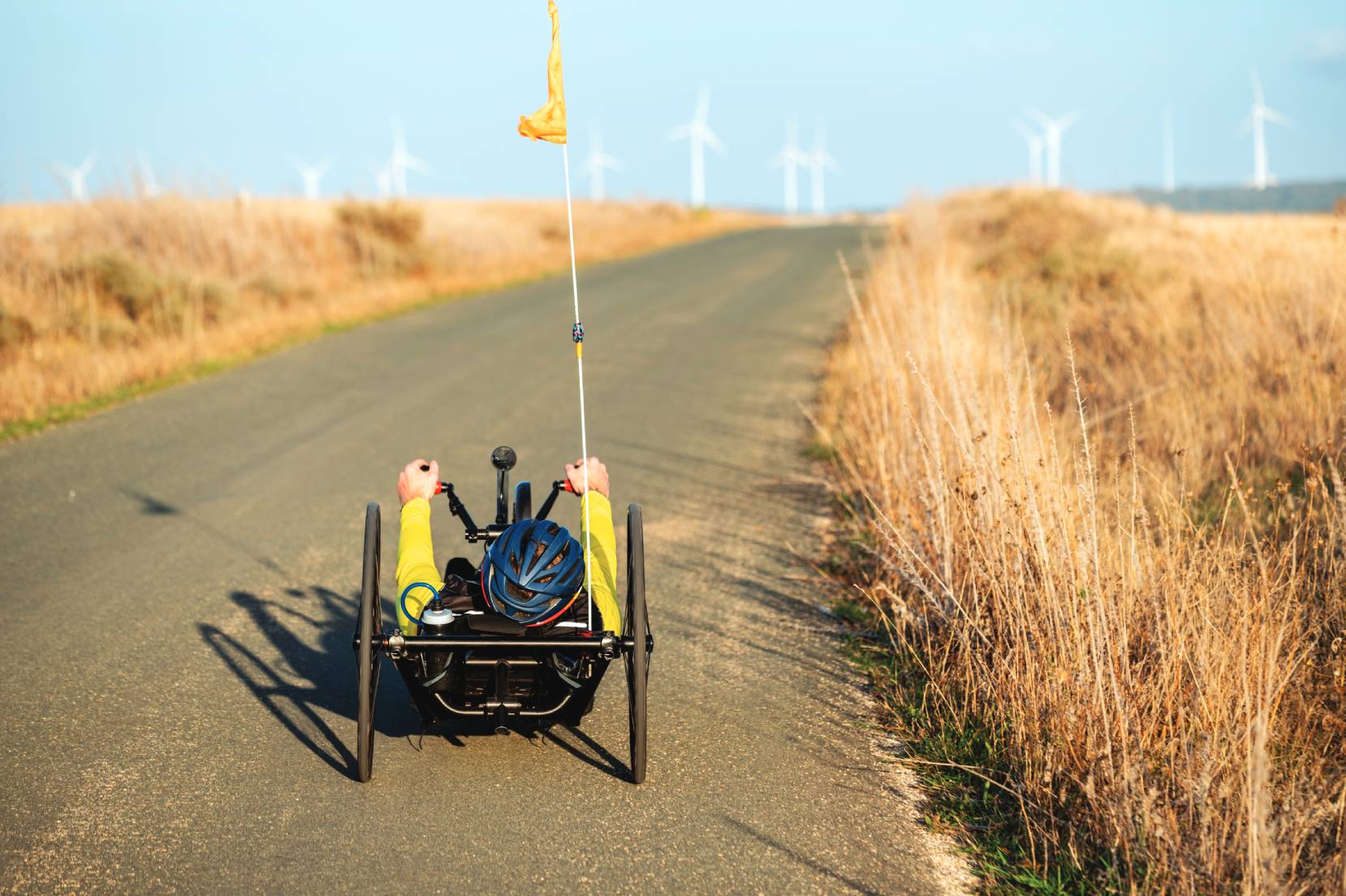 persona in handbike su una strada asfaltata