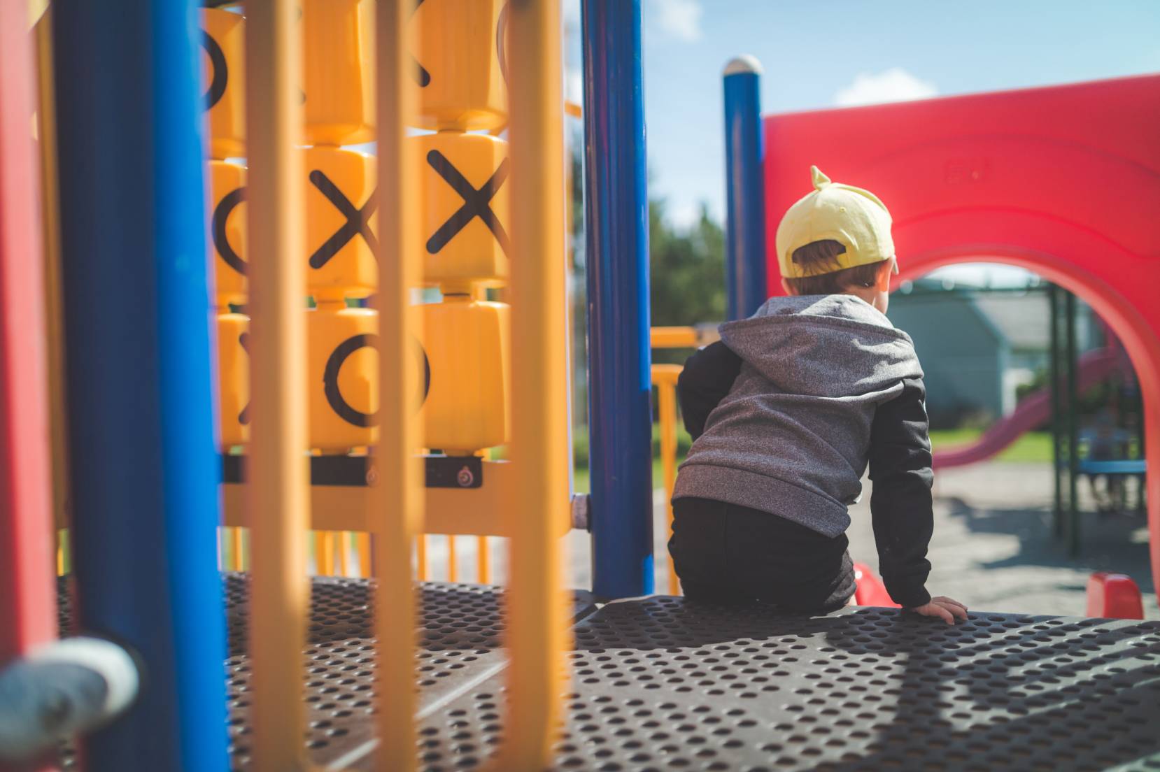un bambino ritratto di spalle all'interno di un parco giochi