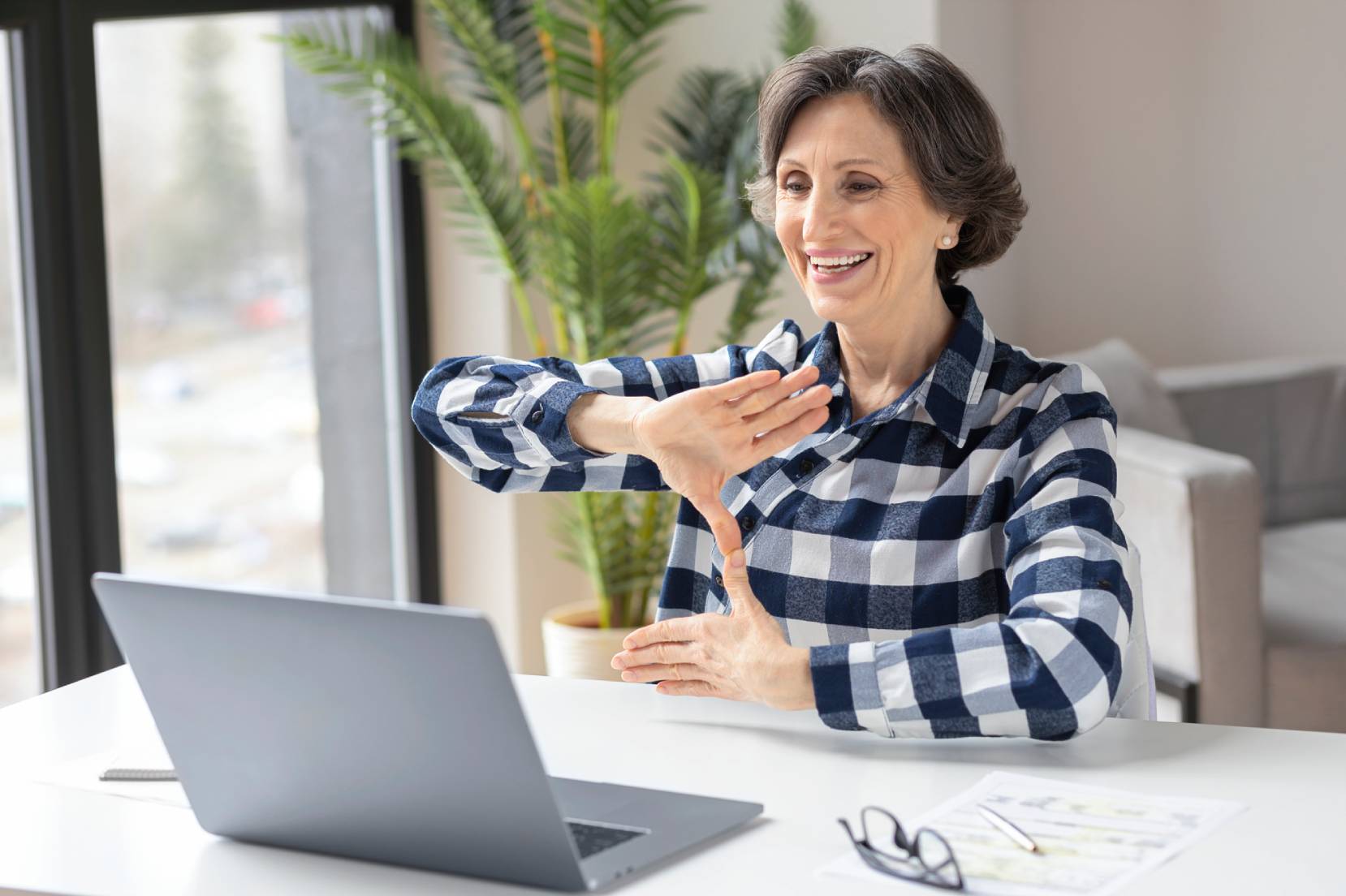 Donna che comunica in lingua dei segni davanti a un Pc 
