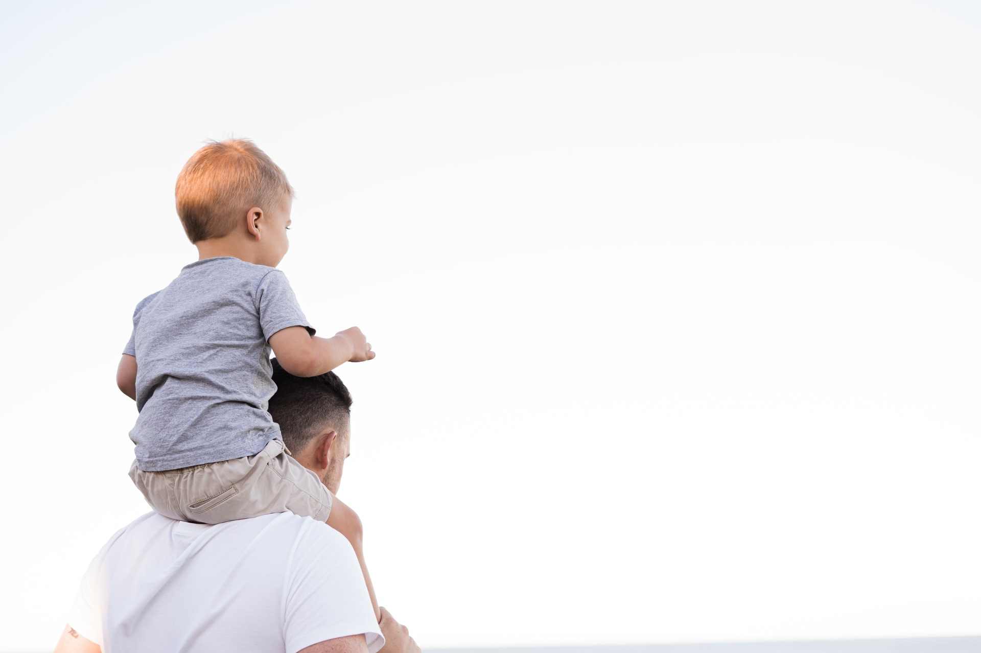 Un papà con bambino sulle spalle