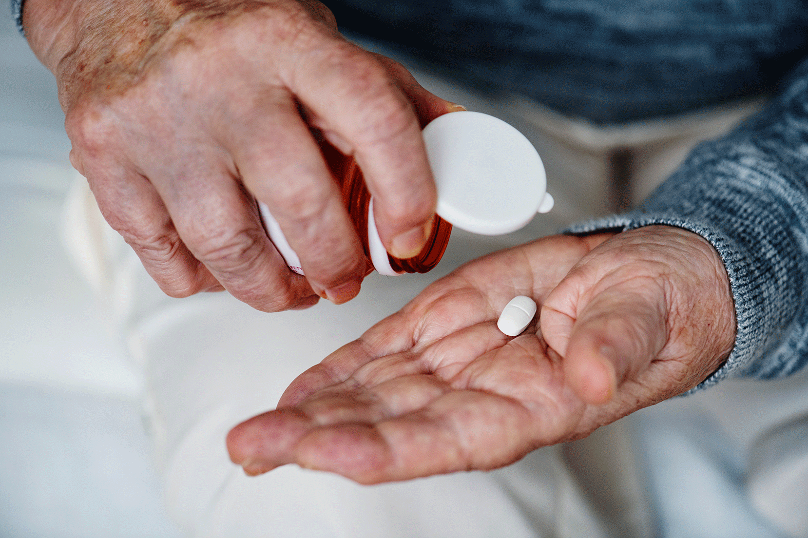 Persona anziana versa pillole